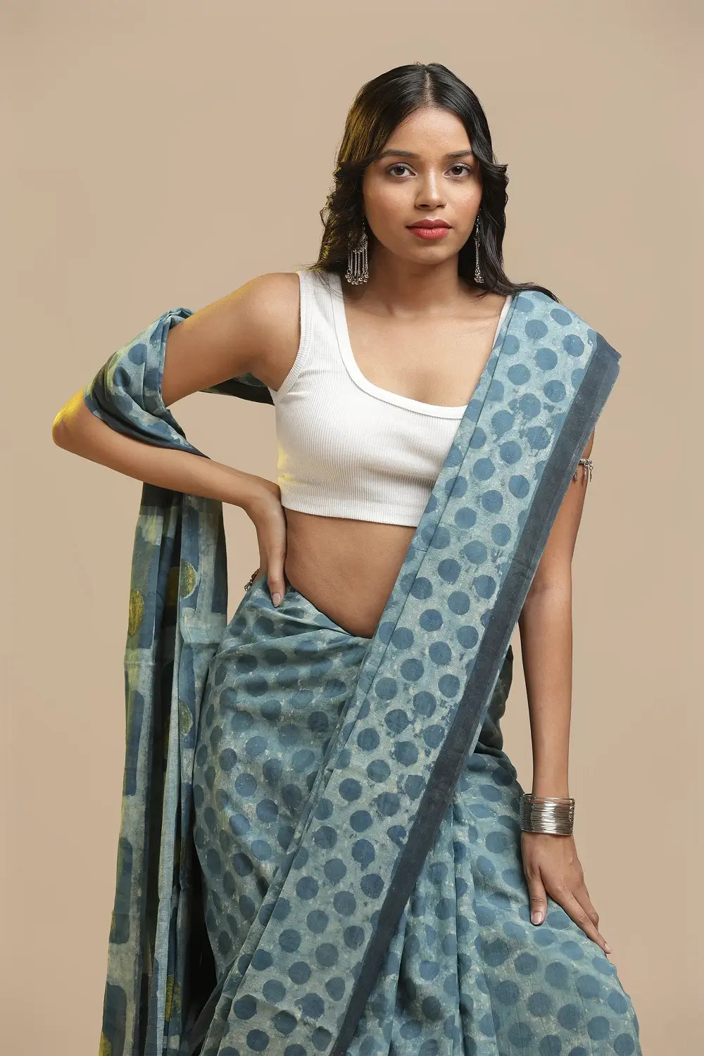 Model posing in the blue polka-dot Bagru cotton saree against a neutral studio backdrop
