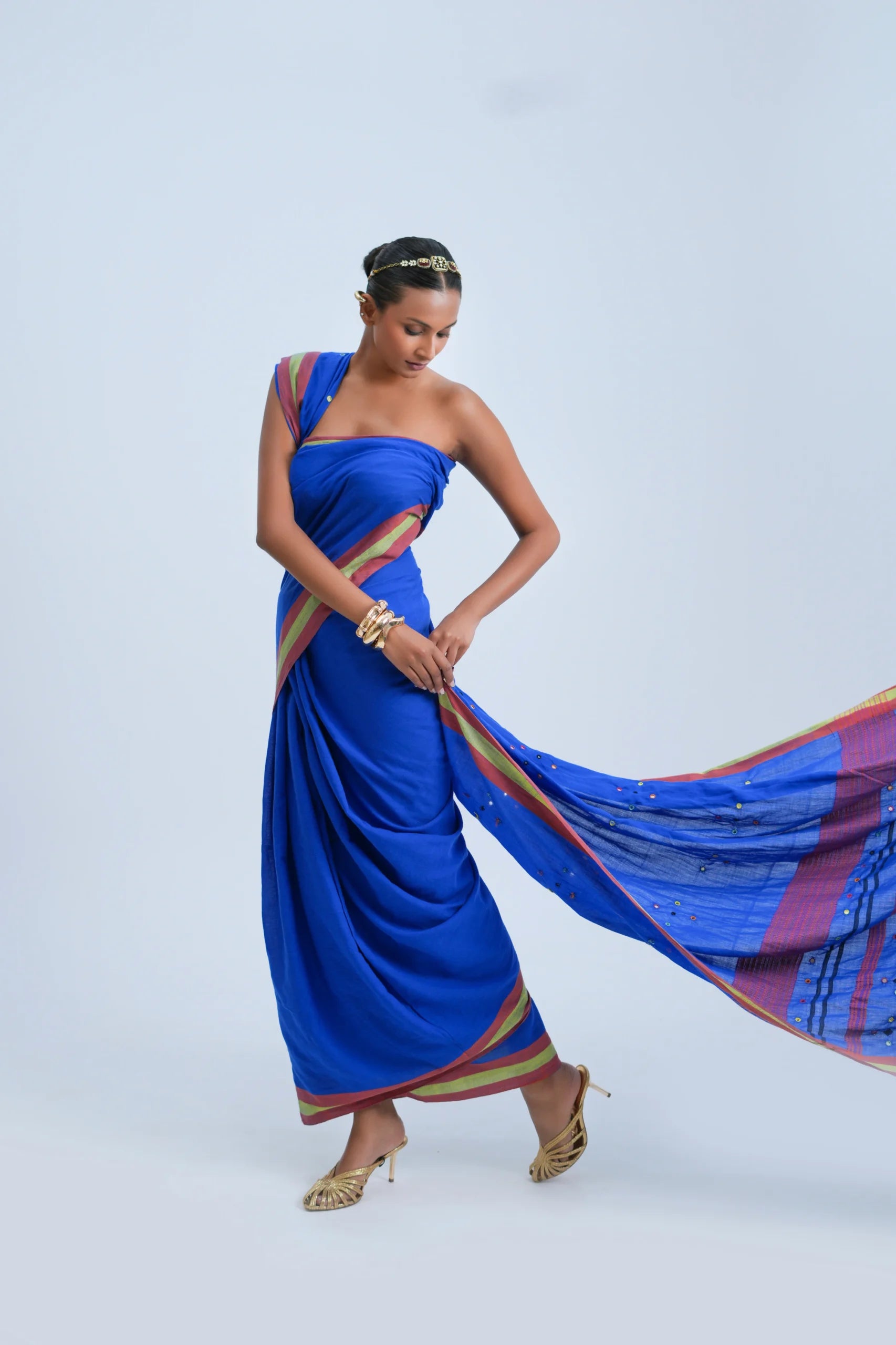 Full-length studio view of a model wearing the electric royal blue organic Kala cotton Bhujodi saree featuring a maroon and olive-green border and layered stripe pallu