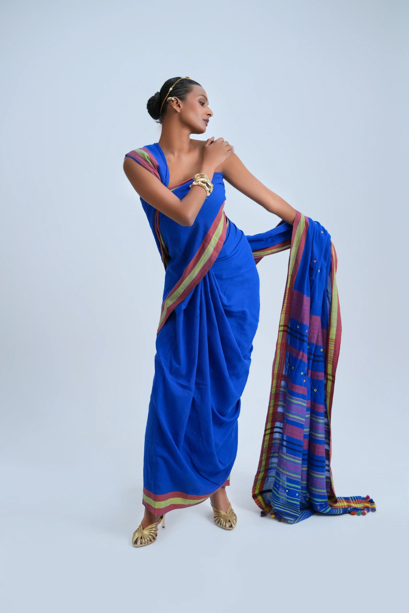 Standing front view showcasing the bold royal blue drape, mirror work embellishments, and detailed pallu spread