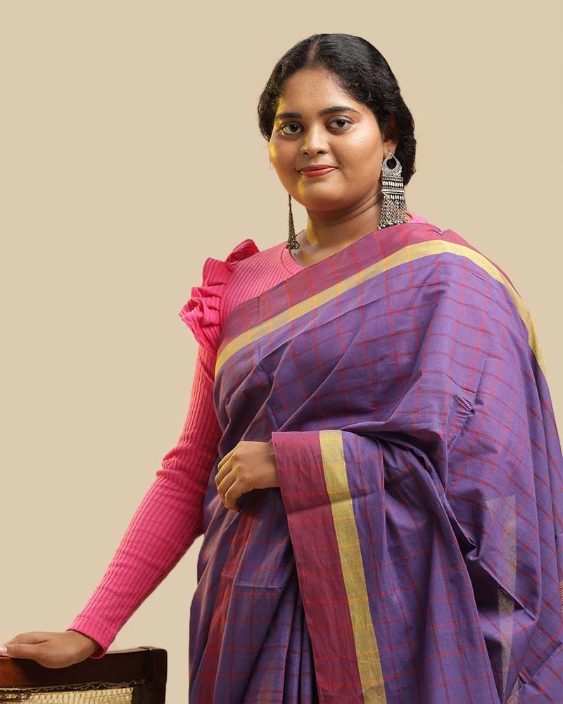 Side-profile studio view showcasing the graceful drape, zari-accented border, and pleated silhouette of the royal purple handloom saree