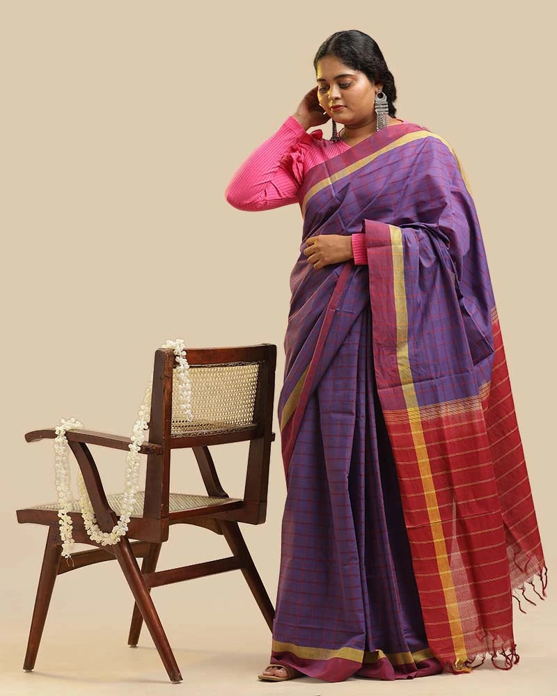 Seated studio view highlighting the rich color harmony, textured weave, and overall styling of the Royal Orchid Kasaragod saree