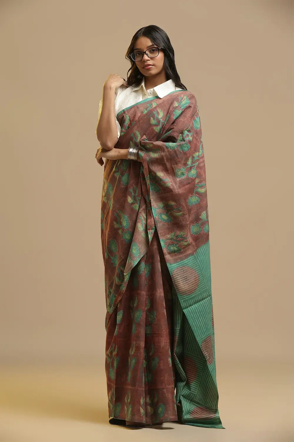 Model posing in the rust brown and green Bagru cotton saree against a neutral studio background
