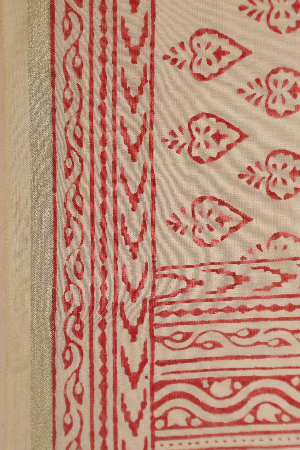 Macro close-up shot focusing on the intricate artisanal red block patterns and fine mercerized weave texture along the saree border