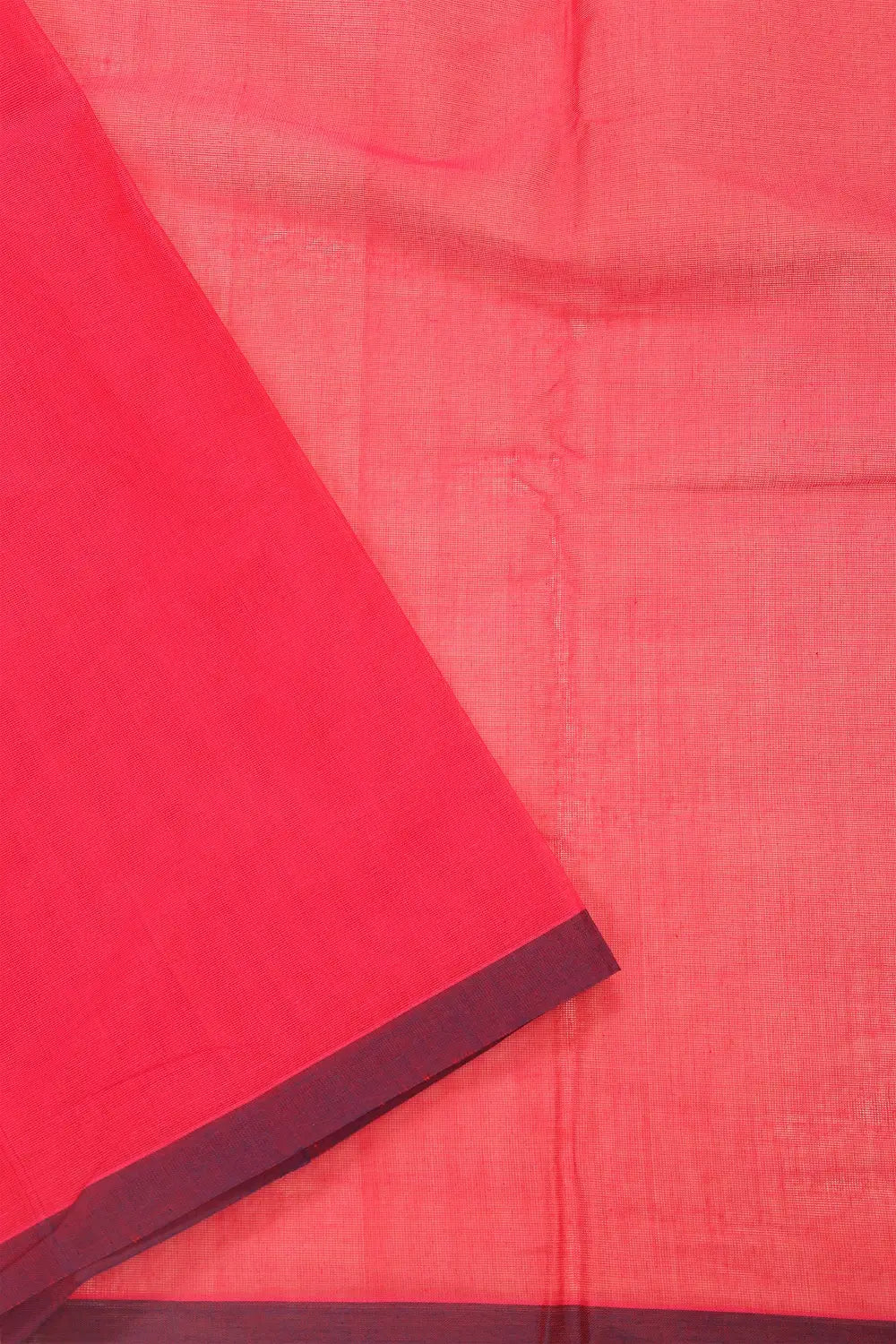 Folded view showcasing the smooth cotton texture and contrasting border weave of the pink Kanchipuram saree
