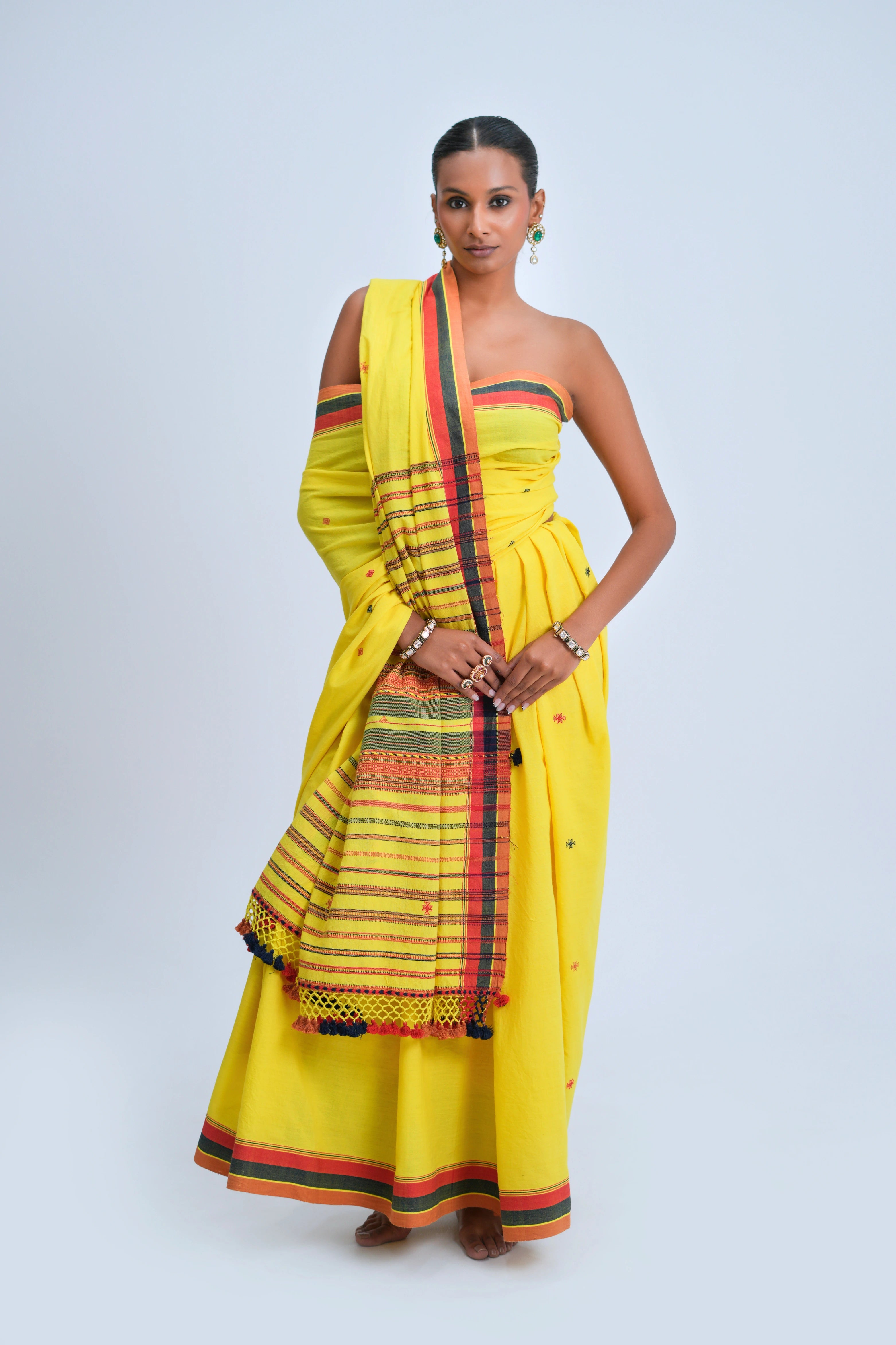 Full-length view of a model wearing the bright sunshine-yellow organic Kala cotton Bhujodi saree featuring a dramatic checked pallu and multicolour borders