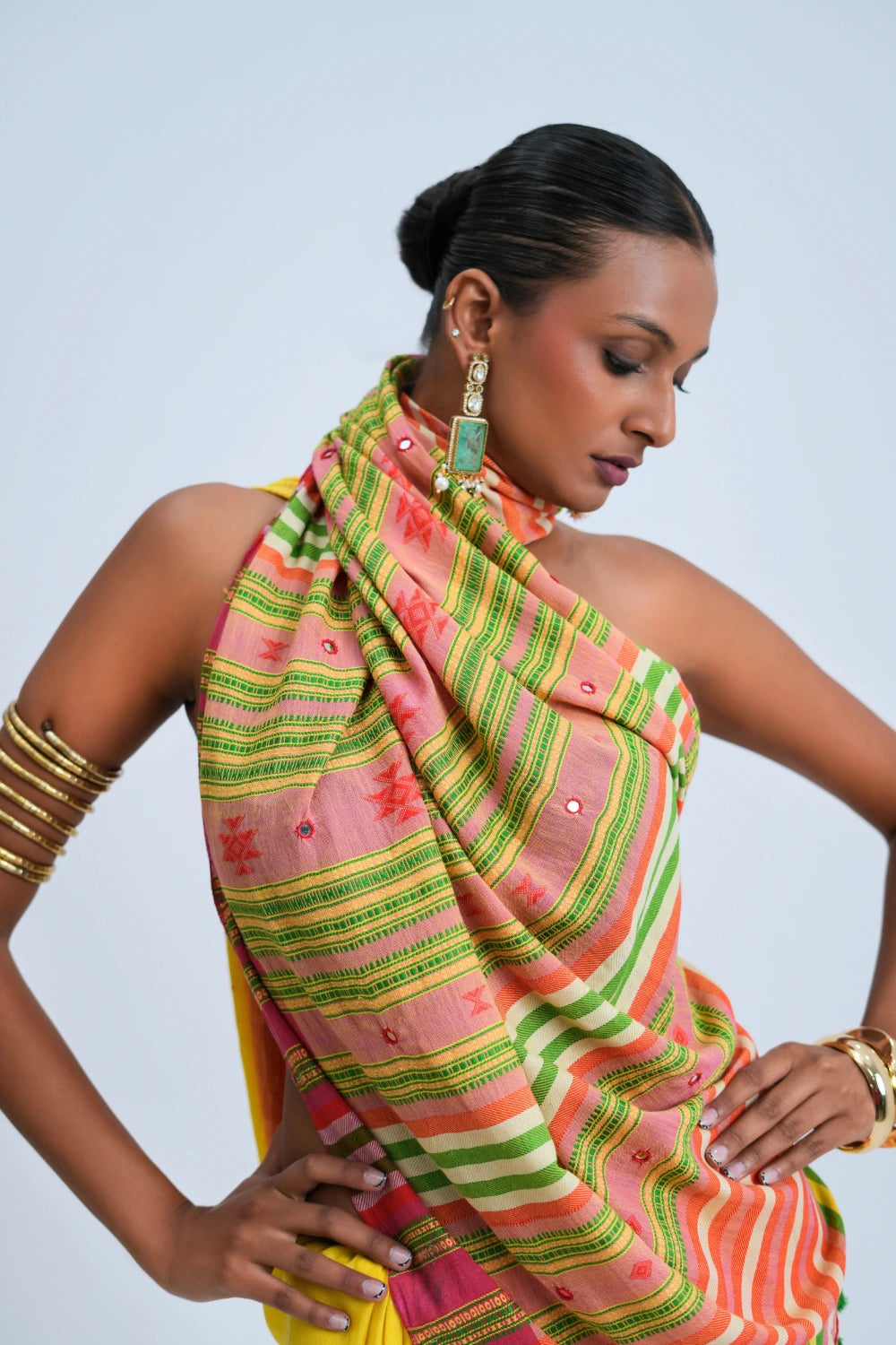 Close-up shoulder drape highlighting the multicolour horizontal stripe pallu, teal-magenta scalloped edge, and delicate tassel fringe