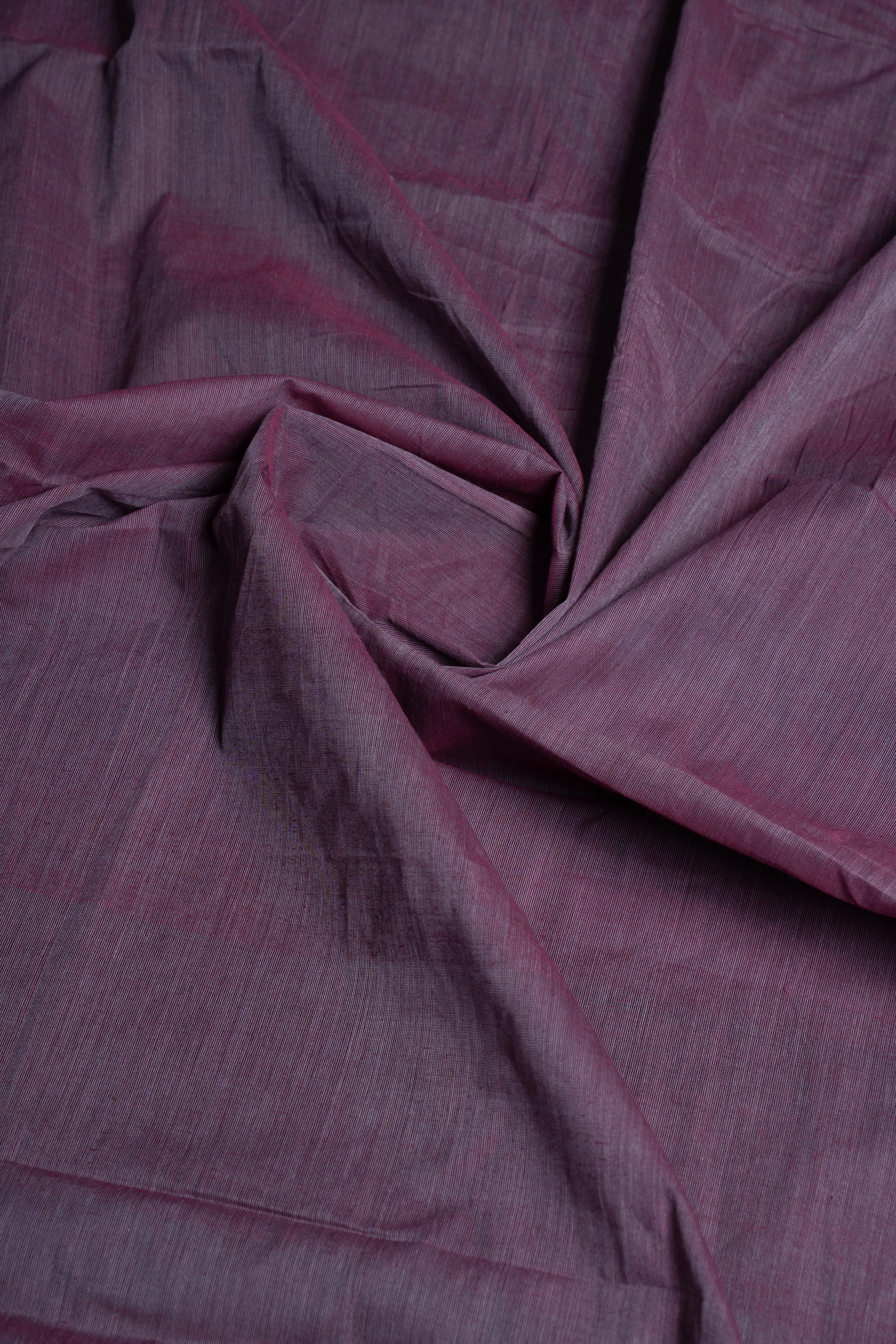 Macro close-up of the folded cotton fabric highlighting the lavender-grey tone and soft, organic handwoven texture