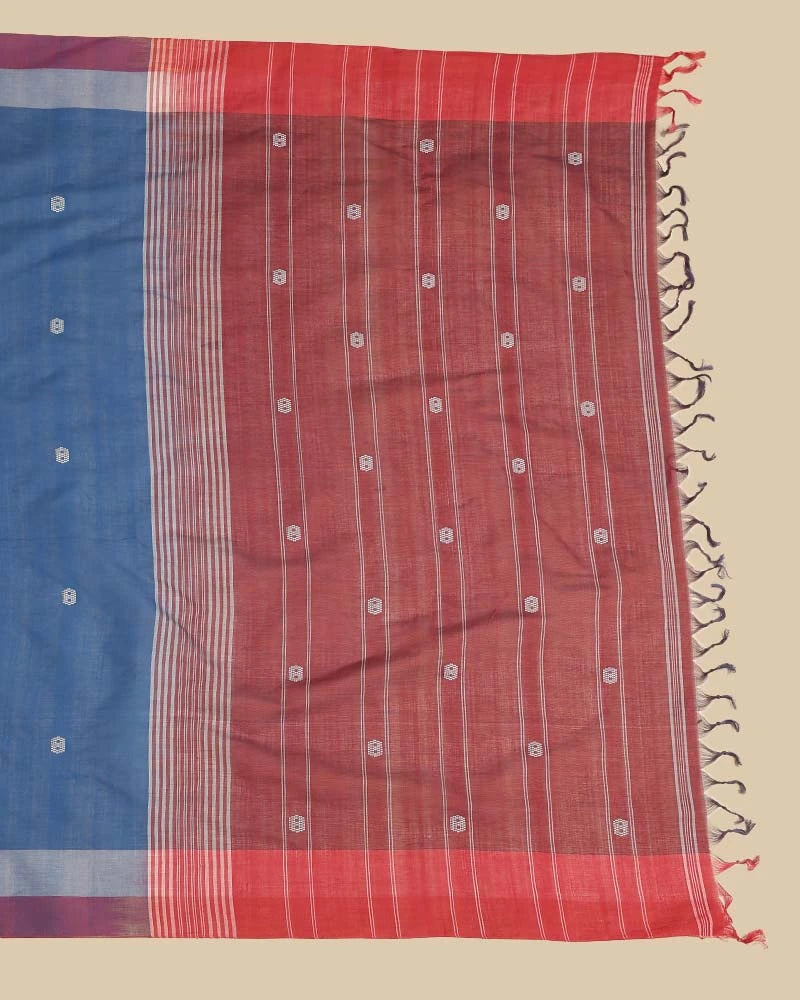 Detailed close-up of the rich maroon pallu featuring traditional woven stripes, buti details, and hand-tied tassel fringe