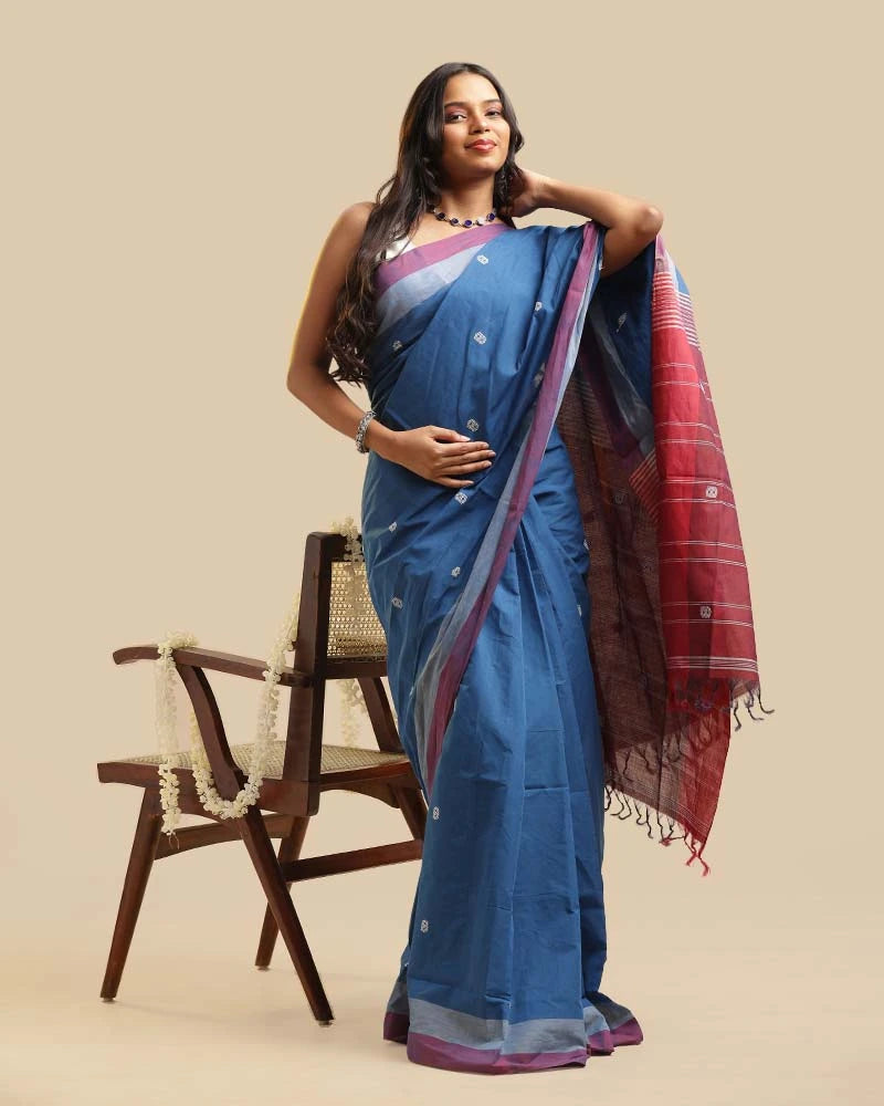 Standing full-length studio view showcasing the serene blue body, soft orchid border, and graceful drape of the Kasaragod handloom saree