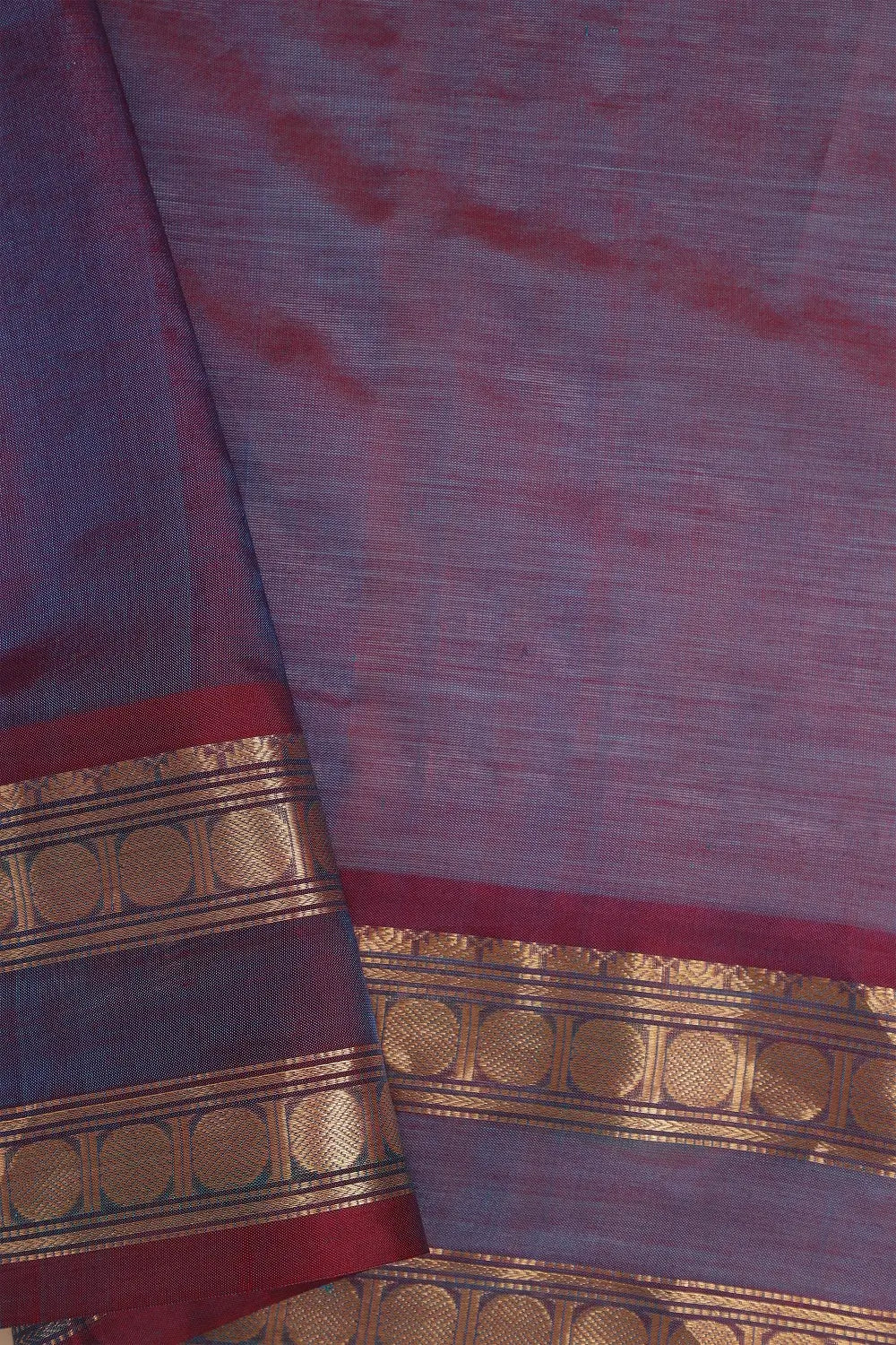 Close-up view of the intricate traditional border work on the lavender silk cotton fabric