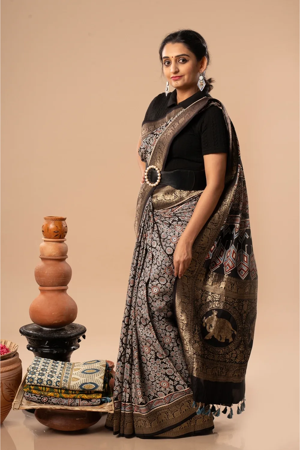Studio standing angle view showcasing the graceful drape, rich black Dola silk body, and traditional hand-block printed patterns
