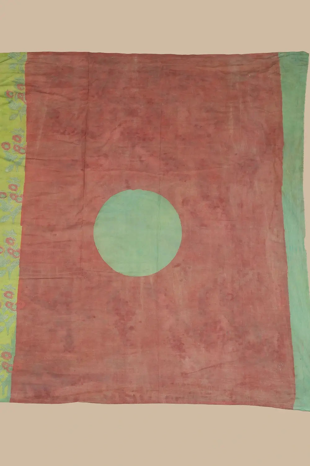 Detail view of the contrasting madder red pallu featuring a central teal circle and broad teal border panel