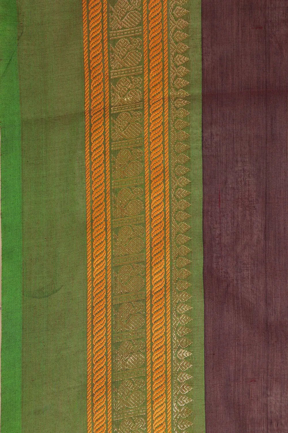 Close-up view of the woven border pattern framing the wine-coloured cotton fabric