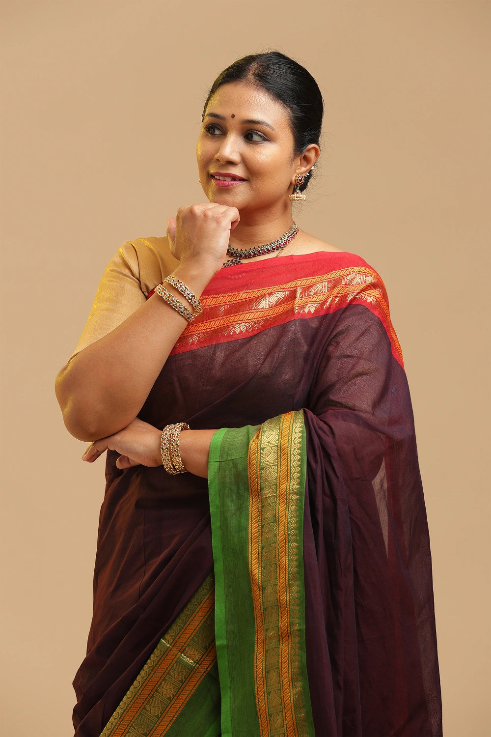 Wine Kanchipuram-inspired pure cotton saree featuring contrasting green and gold borders displayed by a model