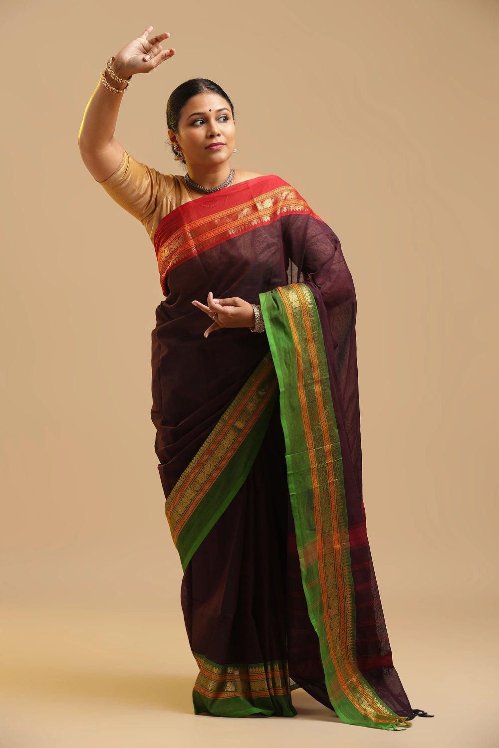 Model gracefully posing in the deep wine cotton saree against a neutral studio backdrop