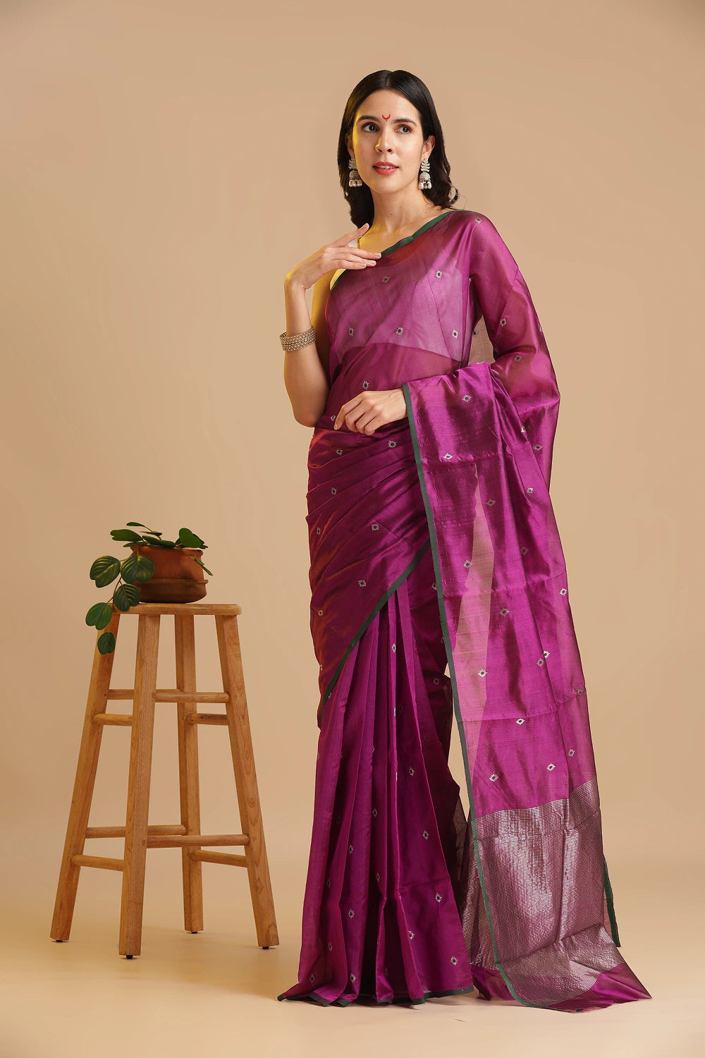 Full-length studio view of a model wearing the magenta handwoven Chanderi pattu silk saree with small green motifs and dark green border, styled with traditional silver jewelry